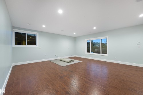 Spare room featuring dark wood-type flooring and recessed lighting - 4811 Woolsey Lane, Edmonton, AB - Indoor Photo Showing Other Room