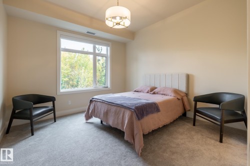Bedroom with carpet and a chandelier - 7471 May Common, Edmonton, AB - Indoor Photo Showing Bedroom