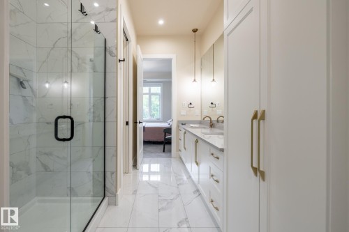 Bathroom featuring a marble finish shower, light marble finish flooring, ensuite bath, double vanity, and recessed lighting - 7471 May Common, Edmonton, AB - Indoor Photo Showing Bathroom