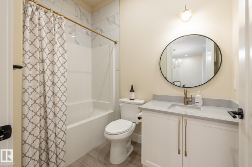 Full bathroom with shower / bath combination with curtain, vanity, and a chandelier - 7471 May Common, Edmonton, AB - Indoor Photo Showing Bathroom