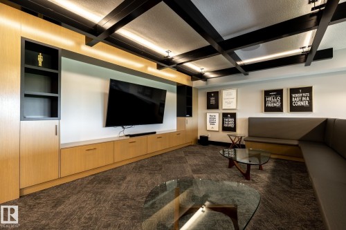 Home theater featuring a textured ceiling, dark carpet, beam ceiling, and coffered ceiling - 7471 May Common, Edmonton, AB - Indoor