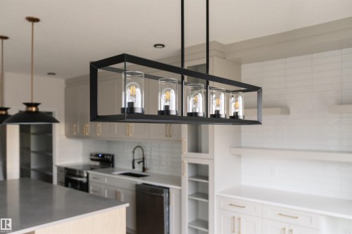 Kitchen featuring open shelves, stainless steel appliances, tasteful backsplash, and a center island - 163 Starling Way, Fort Saskatchewan, AB - Indoor Photo Showing Kitchen