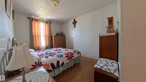 Bedroom with wood finished floors and a textured ceiling - 3122 142 Avenue, Edmonton, AB - Indoor Photo Showing Bedroom