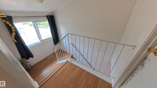 Stairway with wood finished floors and a textured ceiling - 3122 142 Avenue, Edmonton, AB - Indoor Photo Showing Other Room
