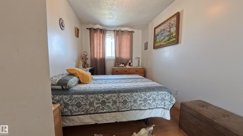 Bedroom with a textured ceiling and wood finished floors - 3122 142 Avenue, Edmonton, AB - Indoor Photo Showing Bedroom