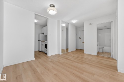 Unfurnished living room featuring light wood-type flooring and baseboards - 207 11007 83 Avenue, Edmonton, AB - Indoor Photo Showing Other Room