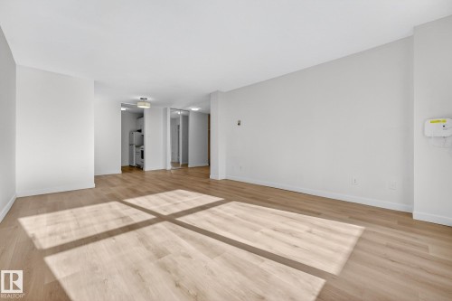 Unfurnished room featuring baseboards and light wood finished floors - 207 11007 83 Avenue, Edmonton, AB - Indoor Photo Showing Other Room