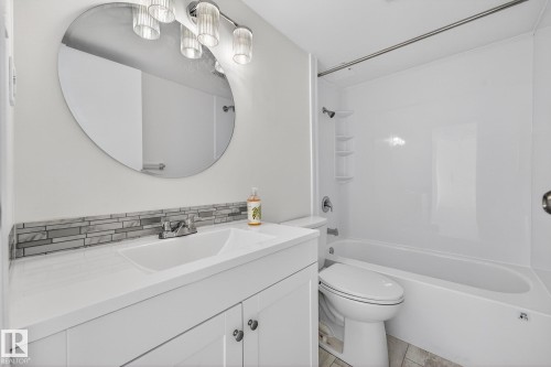 Bathroom featuring vanity, shower / washtub combination, and tasteful backsplash - 207 11007 83 Avenue, Edmonton, AB - Indoor Photo Showing Bathroom