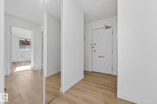Corridor with light wood-style flooring and a textured ceiling - 207 11007 83 Avenue, Edmonton, AB - Indoor Photo Showing Other Room