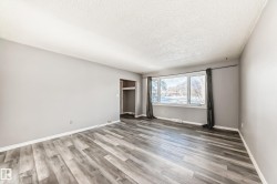 Unfurnished bedroom featuring light wood-style flooring, a textured ceiling, and a closet - 