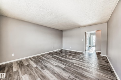 Empty room featuring wood finished floors and a textured ceiling - 8639 64 Avenue Nw, Edmonton, AB - Indoor Photo Showing Other Room