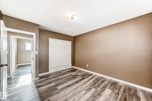 Unfurnished bedroom with a closet and wood finished floors - 8639 64 Avenue Nw, Edmonton, AB - Indoor Photo Showing Other Room
