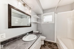 Bathroom with vanity, shower / washtub combination, and dark tile patterned flooring - 