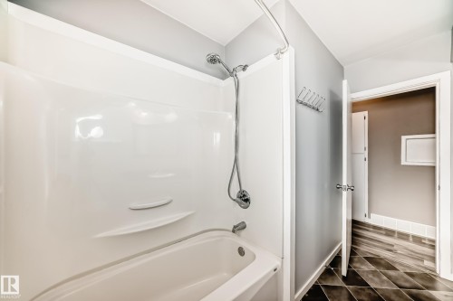 Bathroom with bathing tub / shower combination and baseboards - 8639 64 Avenue Nw, Edmonton, AB - Indoor Photo Showing Bathroom