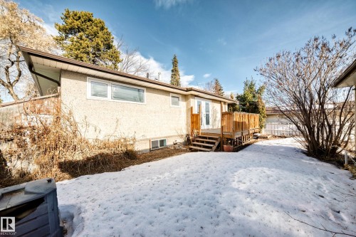 Snow covered house featuring stucco siding and a wooden deck - 8639 64 Avenue Nw, Edmonton, AB - Outdoor
