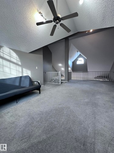 Additional living space with a textured ceiling, a ceiling fan, and carpet flooring - 23 4821 Terwillegar Common, Edmonton, AB - 