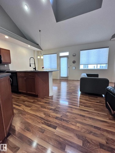 Kitchen with pendant lighting, open floor plan, dark wood-style floors, and dark countertops - 23 4821 Terwillegar Common, Edmonton, AB - Indoor