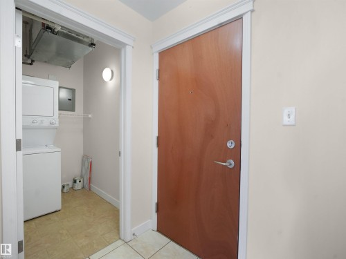 Laundry area with stacked washer and clothes dryer and electric panel - 308 10333 112 Street Street, Edmonton, AB - Indoor Photo Showing Laundry Room