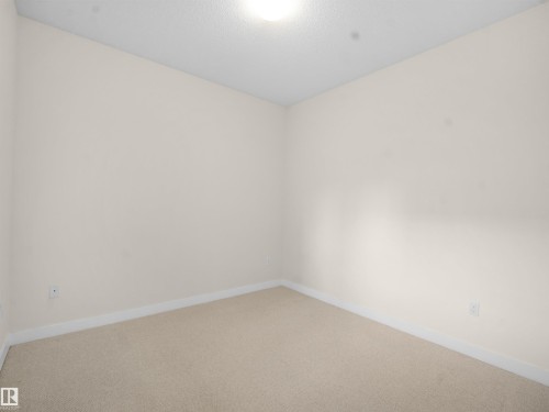 Carpeted spare room featuring baseboards - 308 10333 112 Street Street, Edmonton, AB - Indoor Photo Showing Other Room