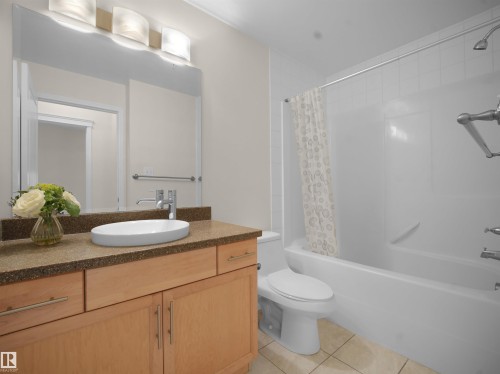 Full bath with vanity, shower / tub combo, and light tile patterned floors - 308 10333 112 Street Street, Edmonton, AB - Indoor Photo Showing Bathroom