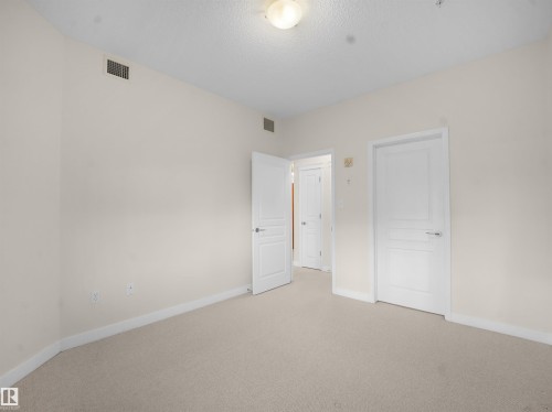 Unfurnished bedroom with carpet floors and baseboards - 308 10333 112 Street Street, Edmonton, AB - Indoor Photo Showing Other Room