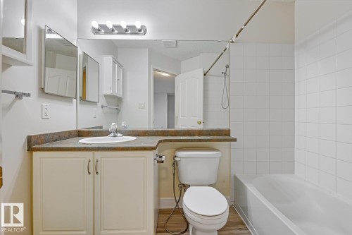 Full bath with bathing tub / shower combination, vanity, and light wood-style floors - 237 17447 98A Avenue, Edmonton, AB - Indoor Photo Showing Bathroom