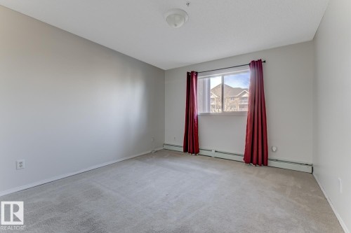 Spare room with light carpet and a baseboard heating unit - 237 17447 98A Avenue, Edmonton, AB - Indoor Photo Showing Other Room