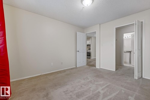 Unfurnished bedroom with light carpet and a textured ceiling - 237 17447 98A Avenue, Edmonton, AB - Indoor Photo Showing Other Room