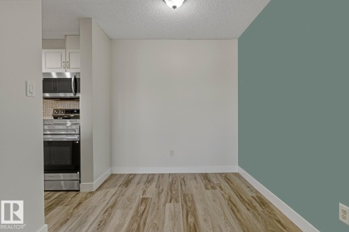 Unfurnished dining area with light wood-style floors and a textured ceiling - 237 17447 98A Avenue, Edmonton, AB - Indoor Photo Showing Other Room