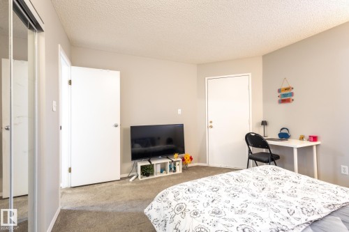 Bedroom featuring a textured ceiling, carpet flooring, and an office area - 3530 42 Street, Edmonton, AB - Indoor Photo Showing Bedroom