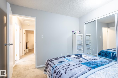 Bedroom with carpet flooring, a textured ceiling, a closet, and attic access - 3530 42 Street, Edmonton, AB - Indoor Photo Showing Bedroom