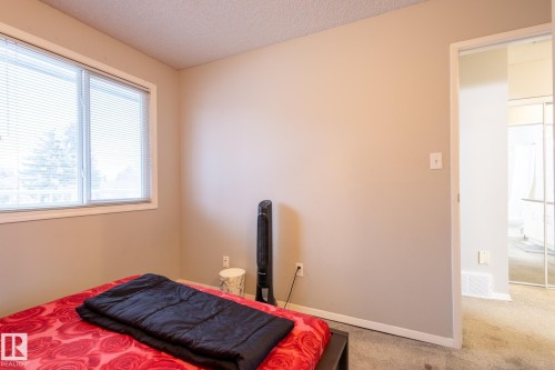 Carpeted bedroom featuring a textured ceiling and baseboards - 3530 42 Street, Edmonton, AB - Indoor Photo Showing Bedroom