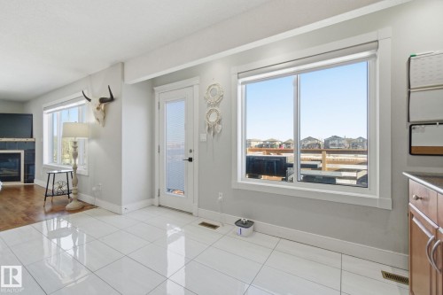 Dining room featuring light tile patterned flooring and a tiled fireplace - 48 Douglas Crescent, Leduc, AB - Indoor With Fireplace