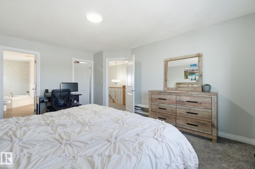 Carpeted bedroom with an office area and ensuite bathroom - 48 Douglas Crescent, Leduc, AB - Indoor Photo Showing Bedroom