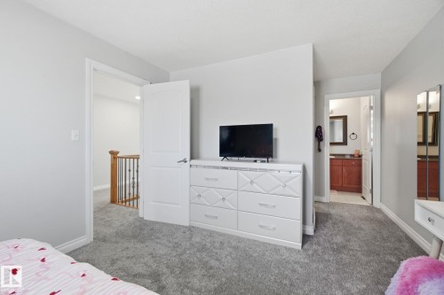 Bedroom with light carpet and connected bathroom - 48 Douglas Crescent, Leduc, AB - Indoor Photo Showing Bedroom