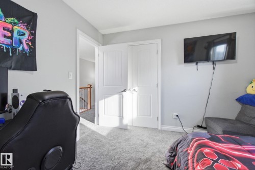 Carpeted bedroom with an office area and a closet - 48 Douglas Crescent, Leduc, AB - Indoor Photo Showing Bedroom