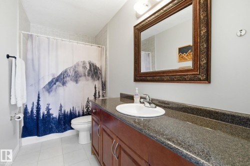 Bathroom featuring vanity, light tile patterned floors, and shower / bath combo with shower curtain - 48 Douglas Crescent, Leduc, AB - Indoor Photo Showing Bathroom