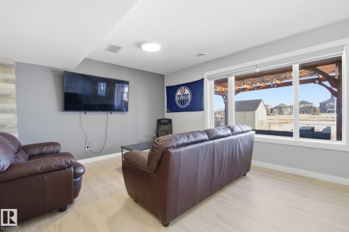 Living area featuring light wood-style flooring and a residential view - 48 Douglas Crescent, Leduc, AB - Indoor Photo Showing Living Room