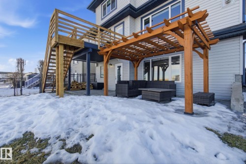 Snow covered back of property featuring a patio area, an outdoor hangout area, and a pergola - 48 Douglas Crescent, Leduc, AB - Outdoor