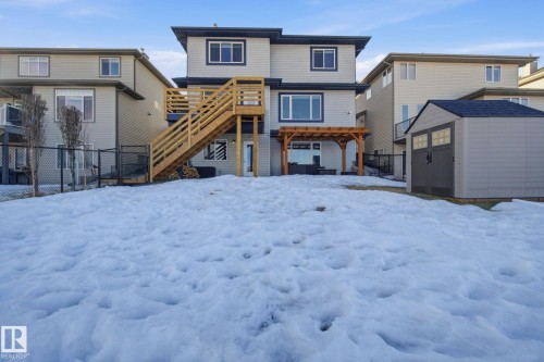 Snow covered house with an outdoor structure, a pergola, a patio, and a deck - 48 Douglas Crescent, Leduc, AB - Outdoor