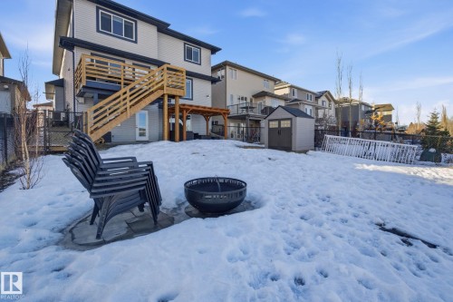 Snow covered house with a patio, a storage unit, a fenced backyard, and a residential view - 48 Douglas Crescent, Leduc, AB - Outdoor