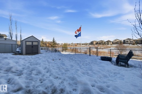 Yard covered in snow with a residential view, a fenced backyard, and a storage shed - 48 Douglas Crescent, Leduc, AB - Outdoor