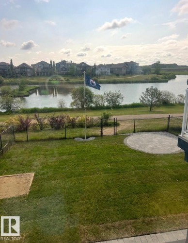 View of property's community featuring a gate, a residential view, and a water view - 48 Douglas Crescent, Leduc, AB - Outdoor With Body Of Water With View
