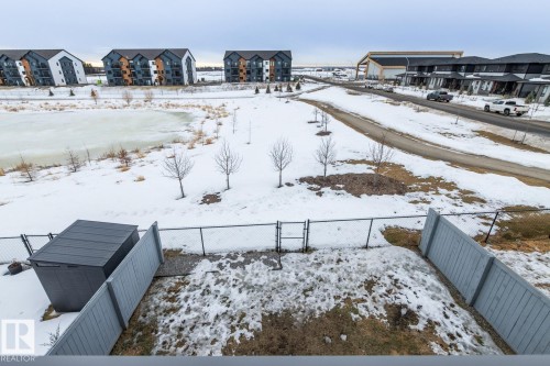 Yard covered in snow with a gate, a fenced backyard, and a residential view - 5 Starling, Fort Saskatchewan, AB 