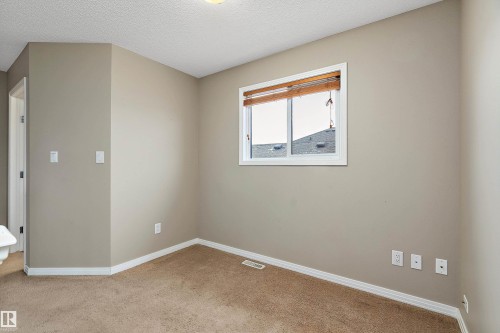 Carpeted spare room with a textured ceiling and baseboards - 33 Sutherland Street, Leduc, AB - Indoor Photo Showing Other Room