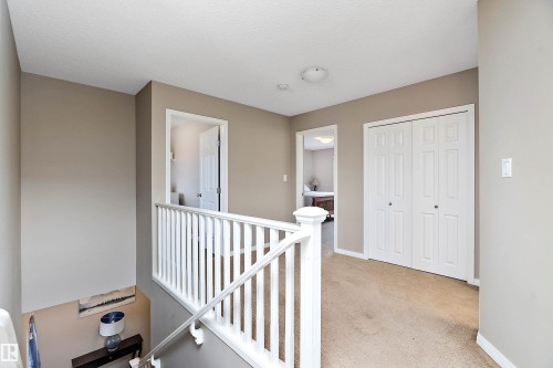 Hallway featuring light carpet and an upstairs landing - 33 Sutherland Street, Leduc, AB - Indoor Photo Showing Other Room