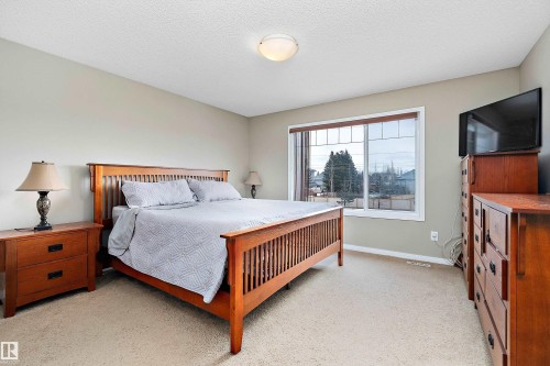 Bedroom featuring light carpet and a textured ceiling - 33 Sutherland Street, Leduc, AB - Indoor Photo Showing Bedroom