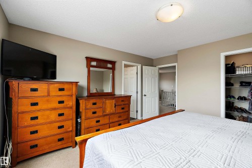 Bedroom featuring light colored carpet, a textured ceiling, and a closet - 33 Sutherland Street, Leduc, AB - Indoor Photo Showing Bedroom