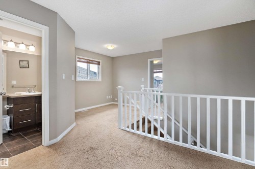 Corridor with carpet flooring and a textured ceiling - 33 Sutherland Street, Leduc, AB - Indoor Photo Showing Other Room