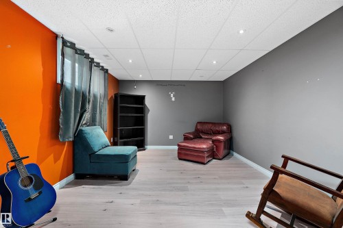 Living area with a drop ceiling and light wood-style flooring - 33 Sutherland Street, Leduc, AB - Indoor